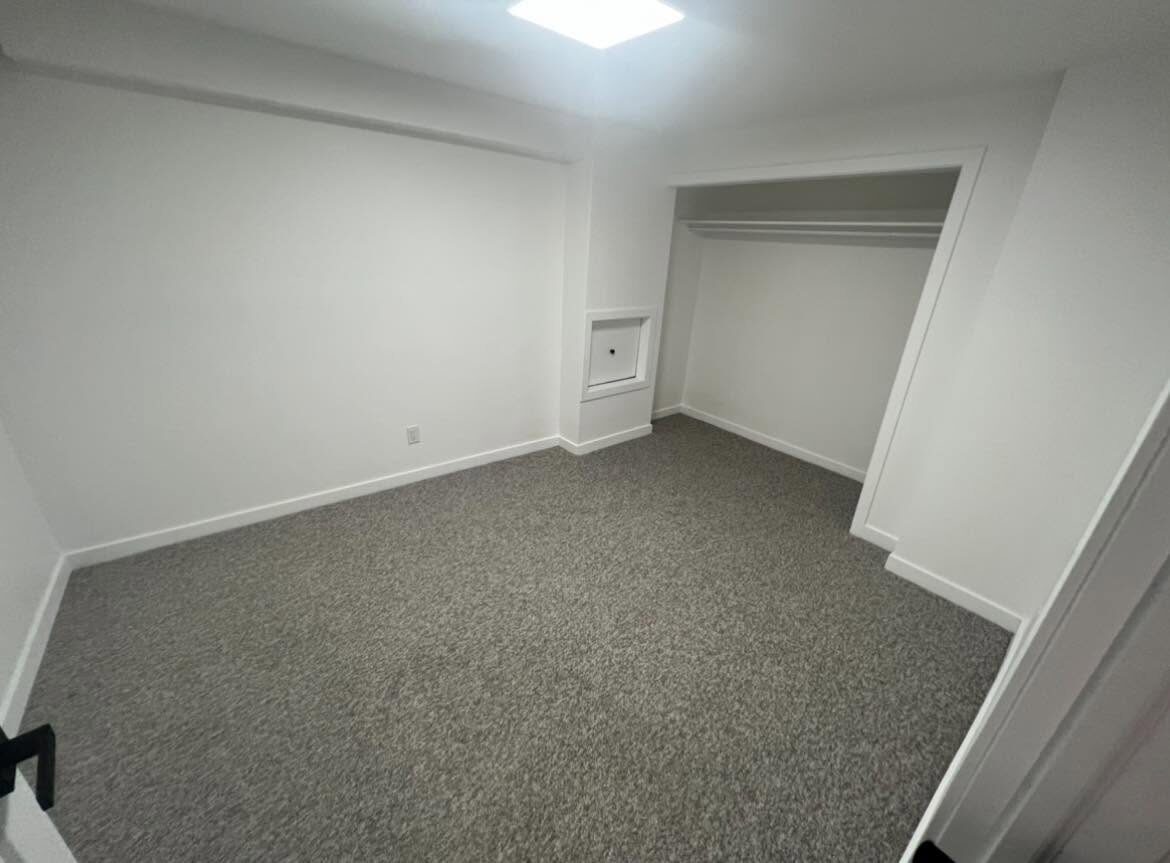 Basement room after — bright finished room with new carpet